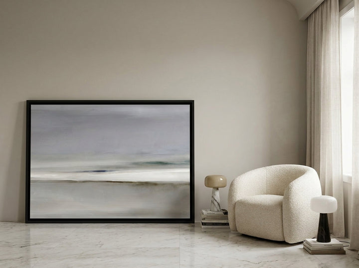 Oversized statement canvas wall art with a black surround leaning against the wall in a luxe bedroom