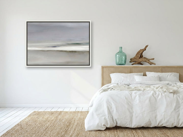 Canvas wall art with a white surround styled on the wall in a coastal bedroom