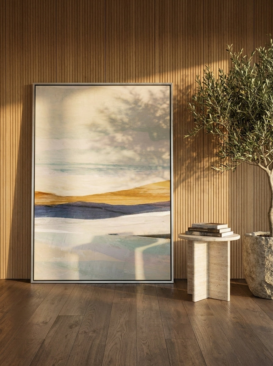 Oversized statement canvas wall art with a silver leaf surround leaning against the wall in a luxe dining room