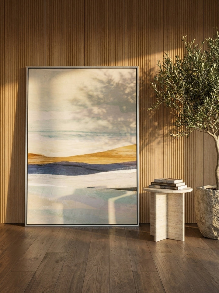 Oversized statement canvas wall art with a silver leaf surround leaning against the wall in a luxe dining room