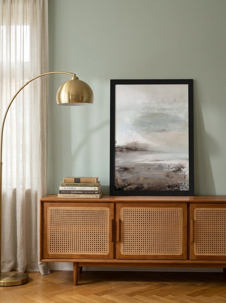 Modern wall art print standing on a sideboard in a mid-century living room