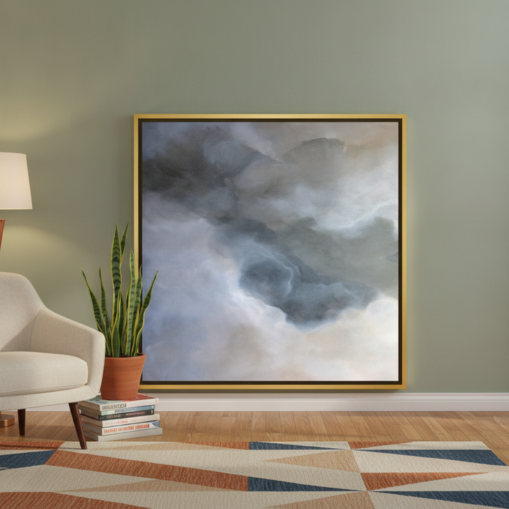 Canvas wall art with a gold leaf surround leaning against the wall in a mid-century living room