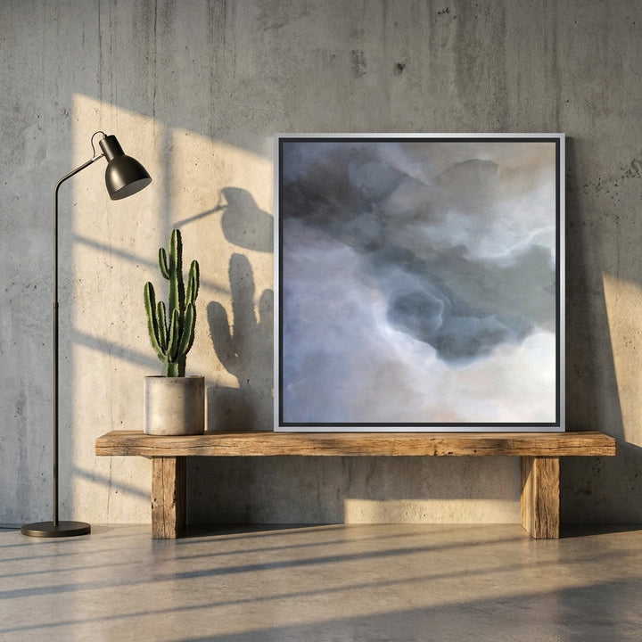 Canvas wall art with a silver leaf surround standing on a bench in an industrial loft bedroom