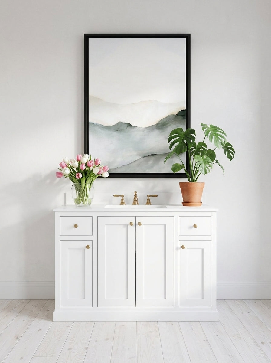 Canvas wall art with a black surround styled on the wall in a bright Scandinavian bathroom
