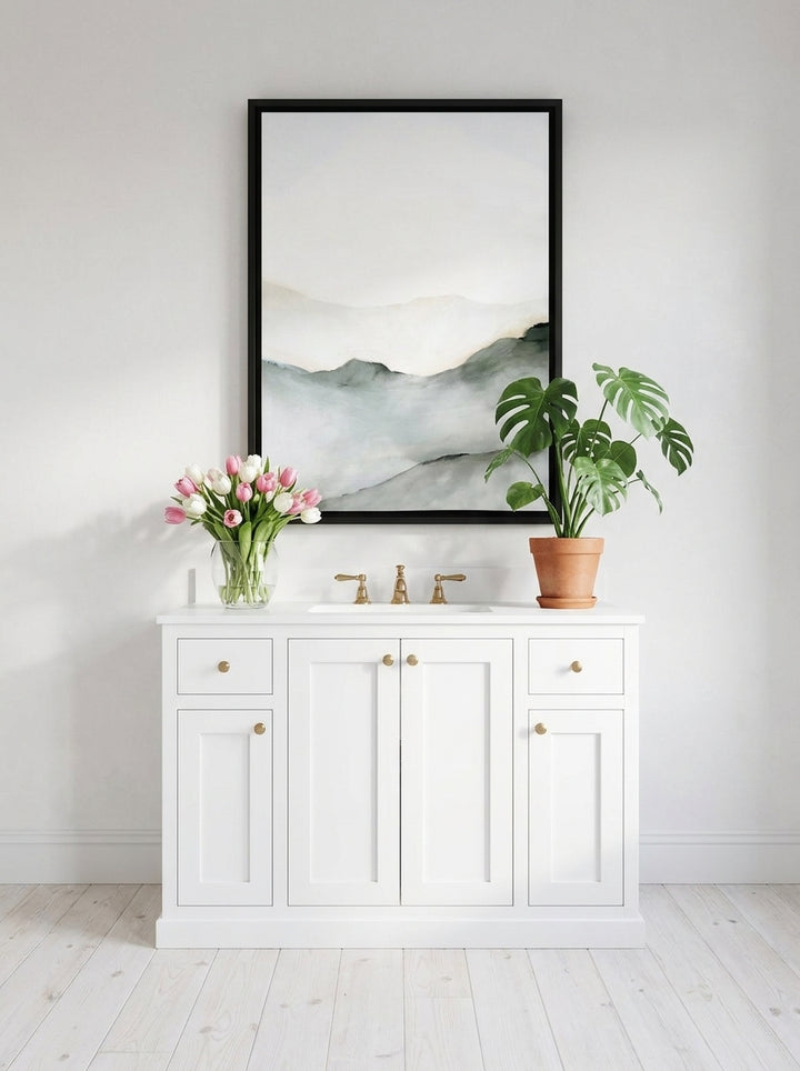 Canvas wall art with a black surround styled on the wall in a bright Scandinavian bathroom