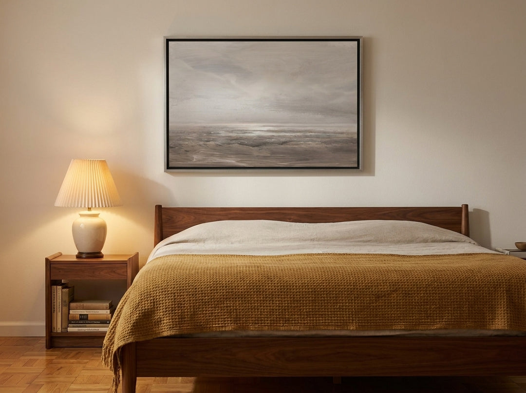 Canvas wall art with a silver leaf surround styled on the wall in a mid-century bedroom