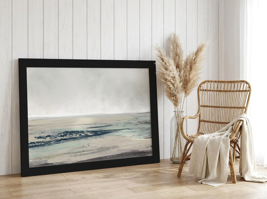 Oversized statement modern wall art print leaning against the wall in a coastal bedroom