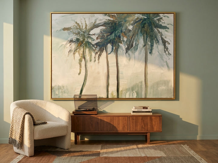 Oversized statement canvas wall art with a gold leaf surround styled on the wall in a mid-century living room