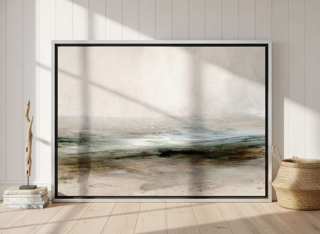 Oversized statement canvas wall art with a silver leaf surround leaning against the wall in a coastal bedroom