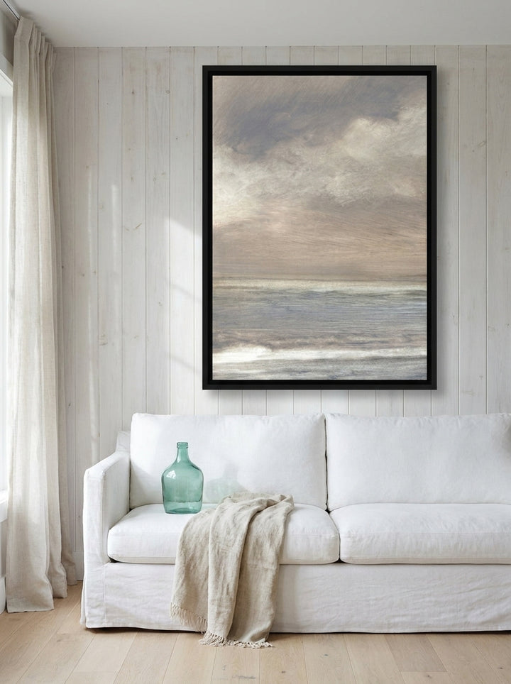 Oversized statement canvas wall art with a black surround styled on the wall in a coastal living room