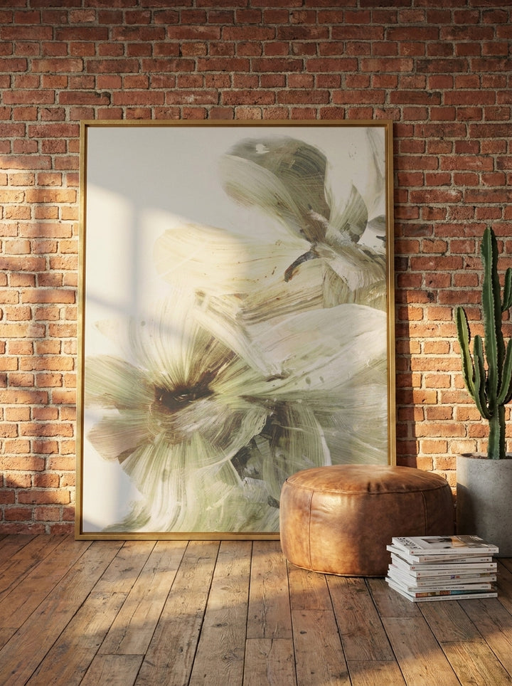 Oversized statement canvas wall art with a gold leaf surround leaning against the wall in an industrial loft dining room