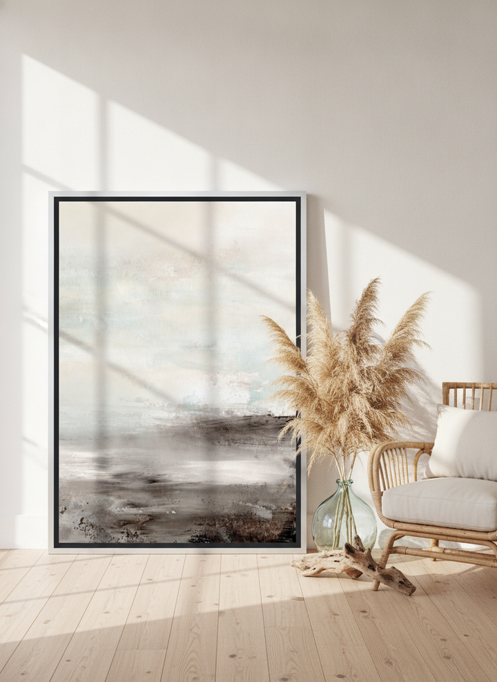 Oversized statement canvas wall art with a silver leaf surround leaning against the wall in a coastal living room