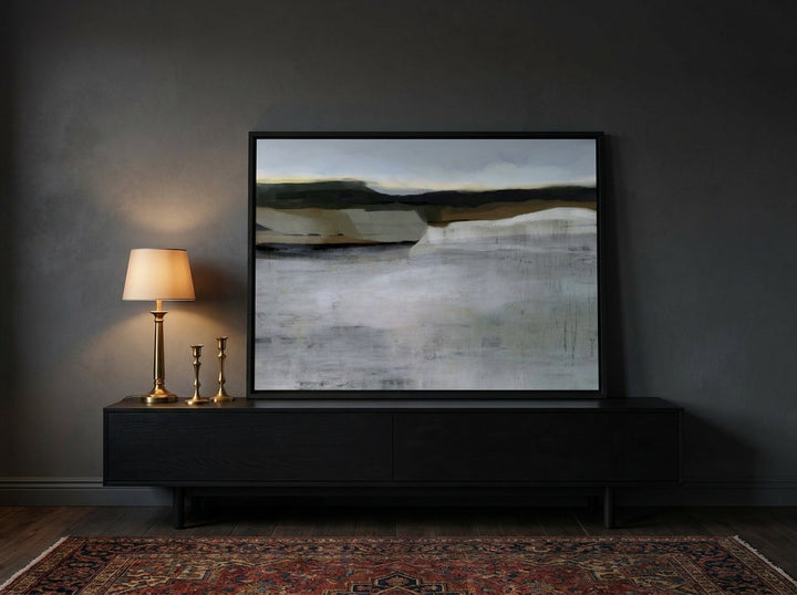 Canvas wall art with a black surround standing on a console in a moody living room