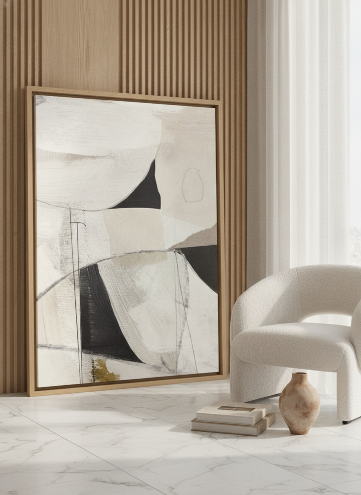 Oversized statement canvas wall art with a natural timber surround leaning against the wall in a luxe living room
