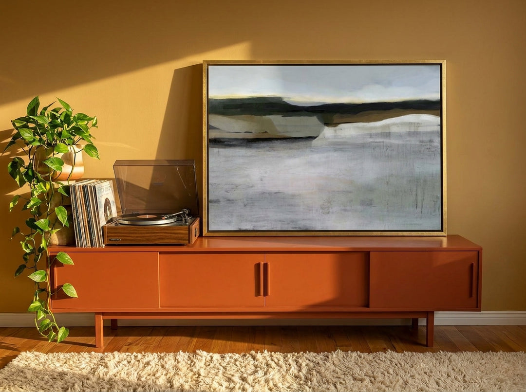 Canvas wall art with a gold leaf surround standing on a sideboard in a retro 70s home office