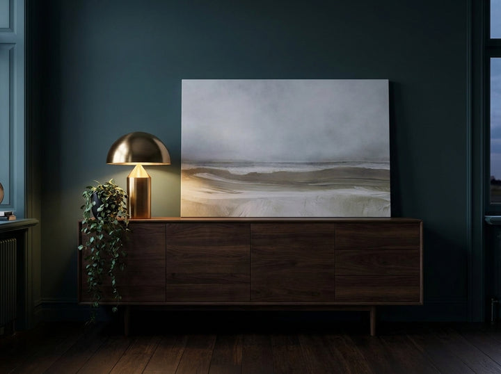 Stretched canvas wall art standing on a sideboard in a moody bedroom