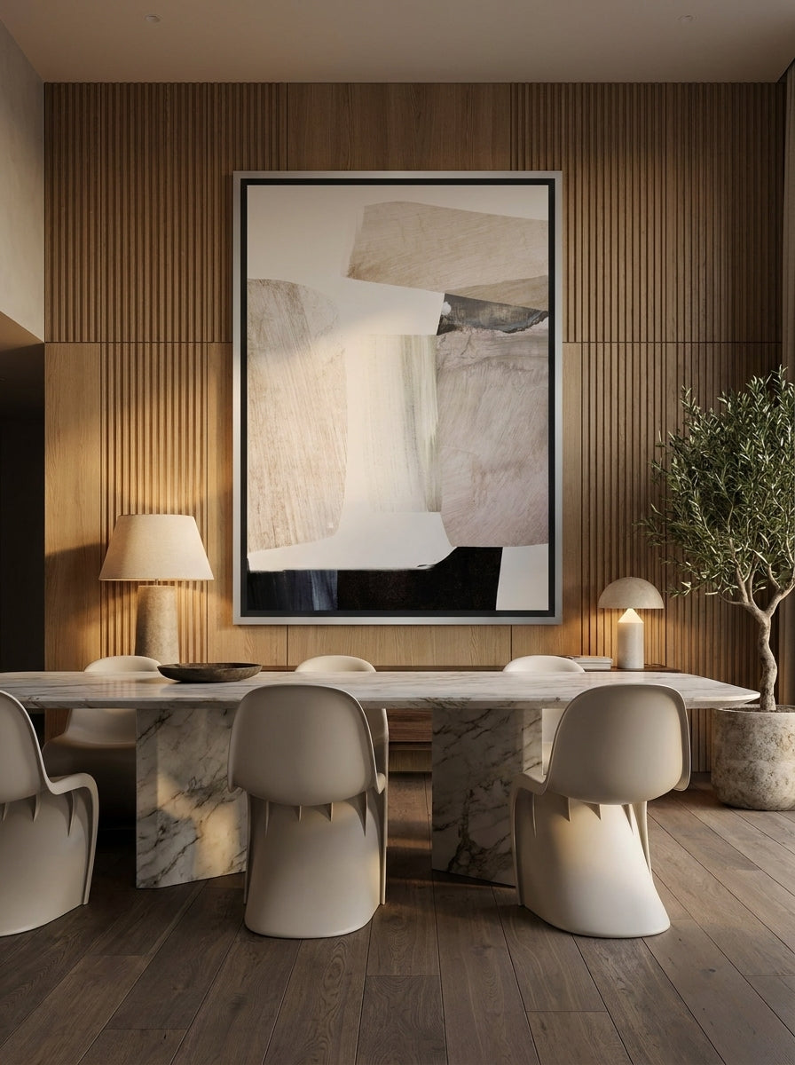 Oversized statement canvas wall art with a silver leaf surround styled on the wall in a luxe dining room