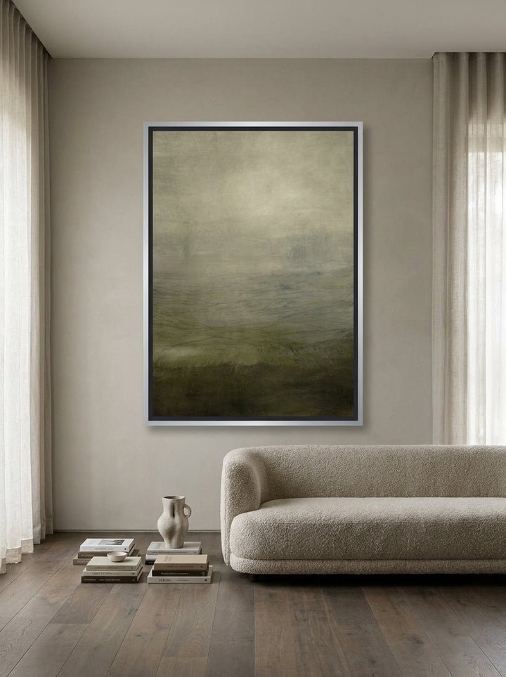 Oversized statement canvas wall art with a silver leaf surround styled on the wall in a luxe living room