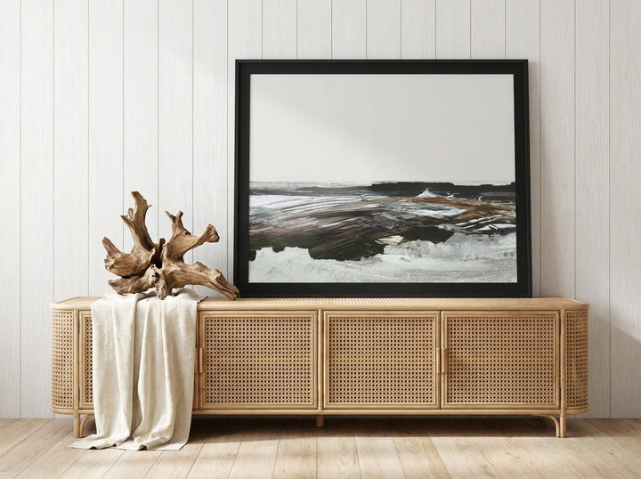 Modern wall art print standing on a sideboard in a coastal dining room