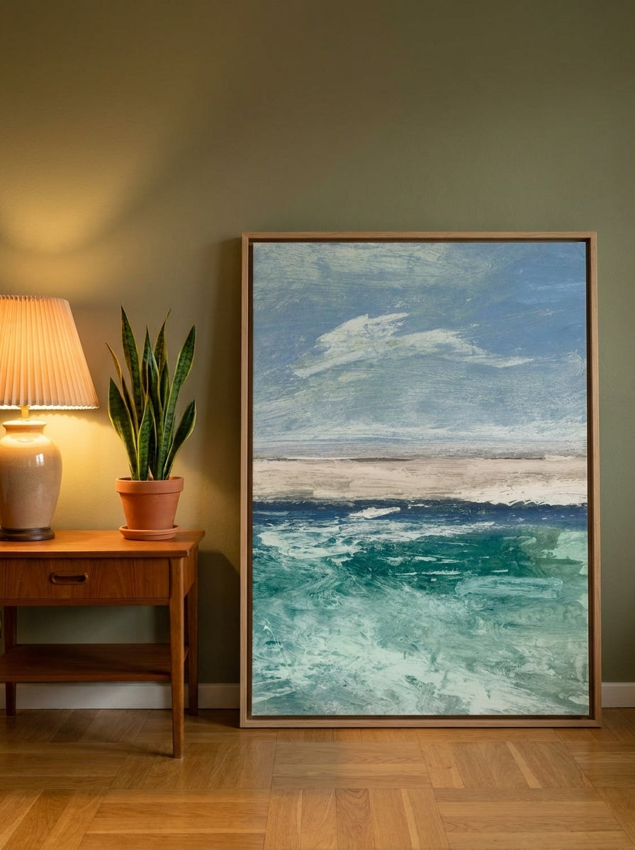 Oversized statement canvas wall art with a natural timber surround leaning against the wall in a mid-century living room