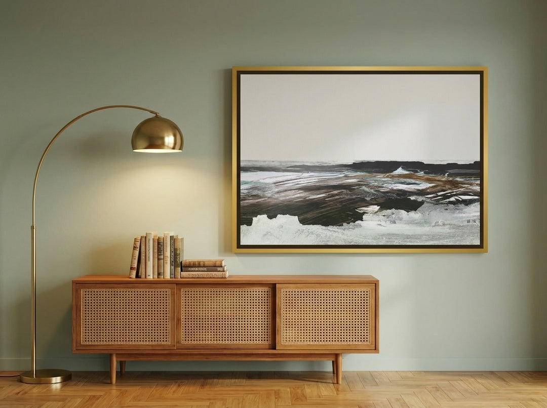 Oversized statement canvas wall art with a gold leaf surround styled on the wall in a mid-century living room