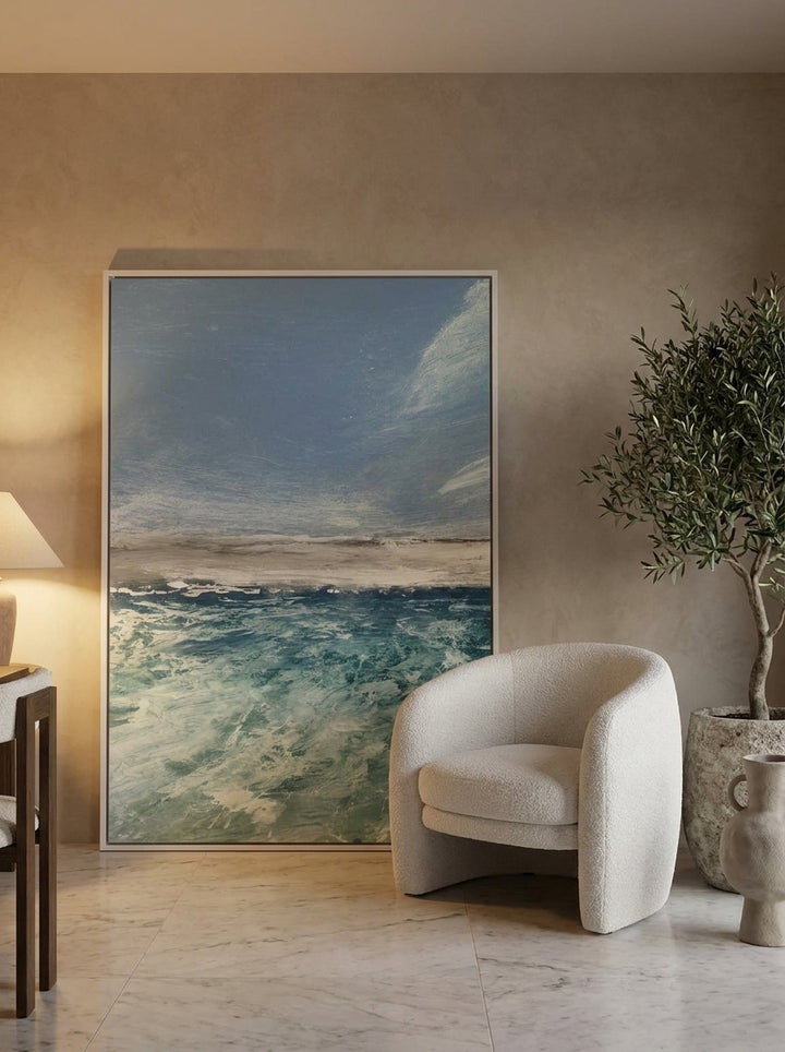Oversized statement canvas wall art with a white surround leaning against the wall in a luxe dining room