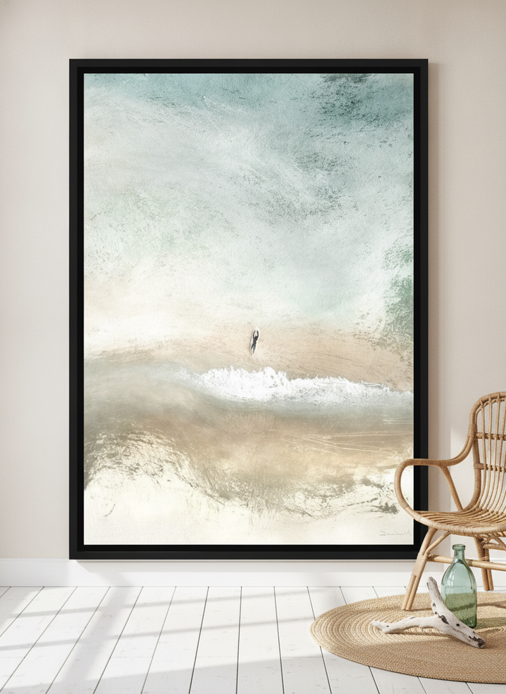 Oversized statement canvas wall art with a black surround leaning against the wall in a coastal bedroom