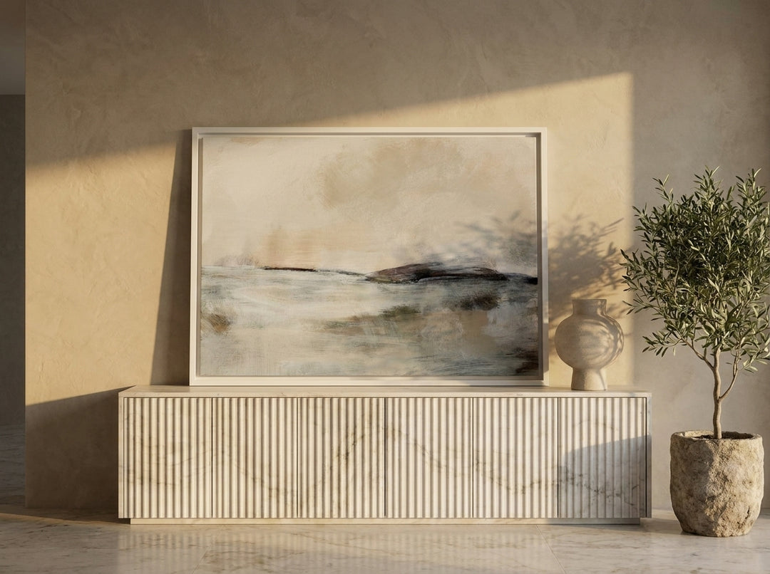Canvas wall art with a white surround standing on a sideboard in a luxe living room