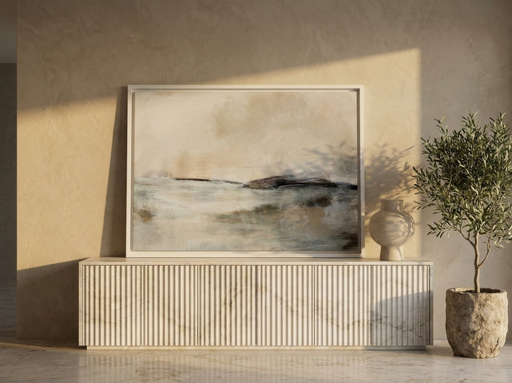 Canvas wall art with a white surround standing on a sideboard in a luxe living room