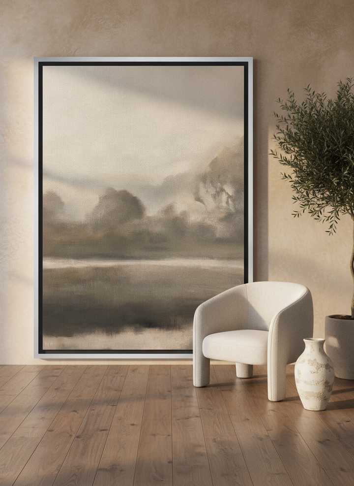 Oversized statement canvas wall art with a silver leaf surround leaning against the wall in a luxe living room