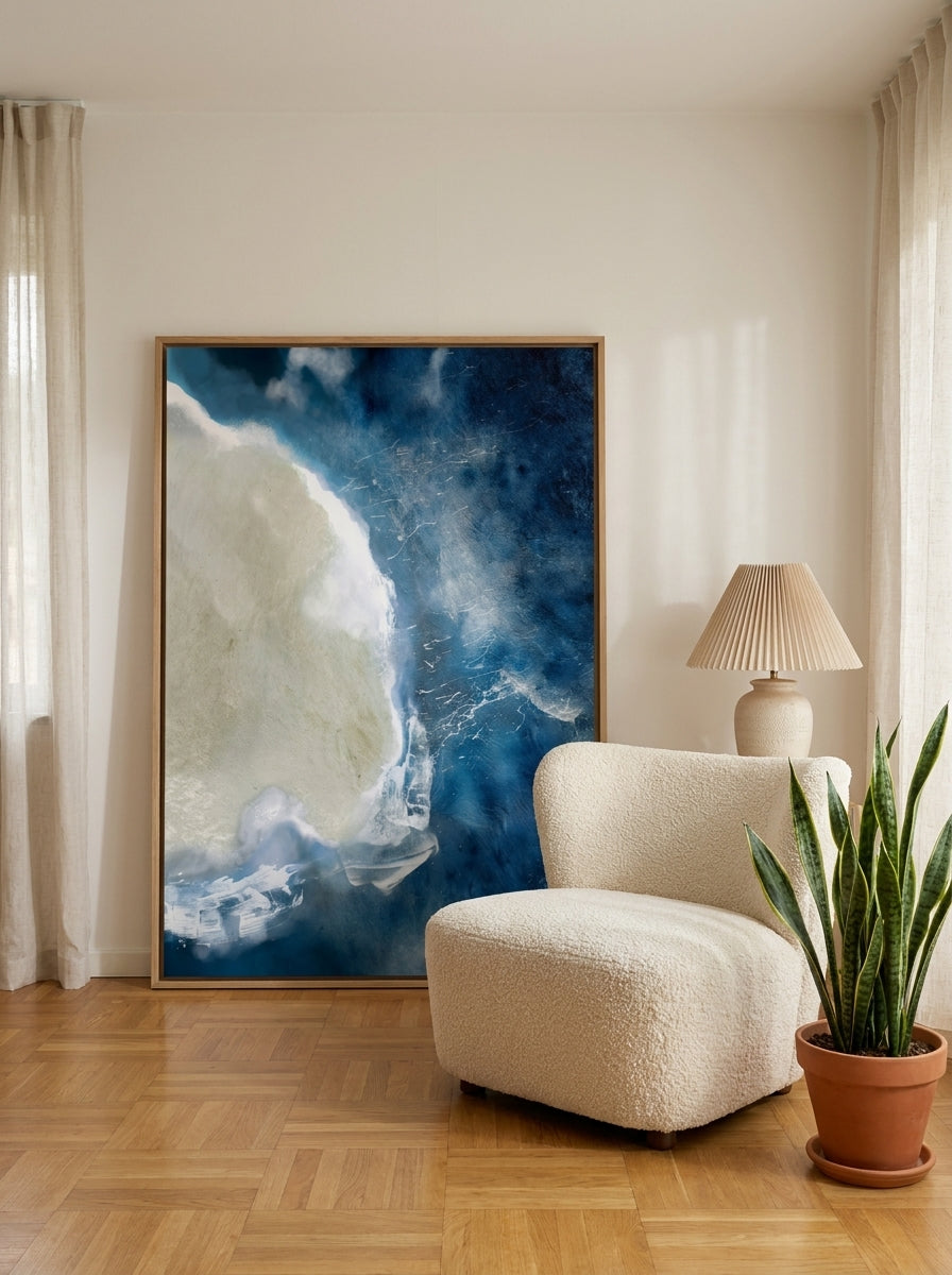 Oversized statement canvas wall art with a natural timber surround leaning against the wall in a mid-century living room