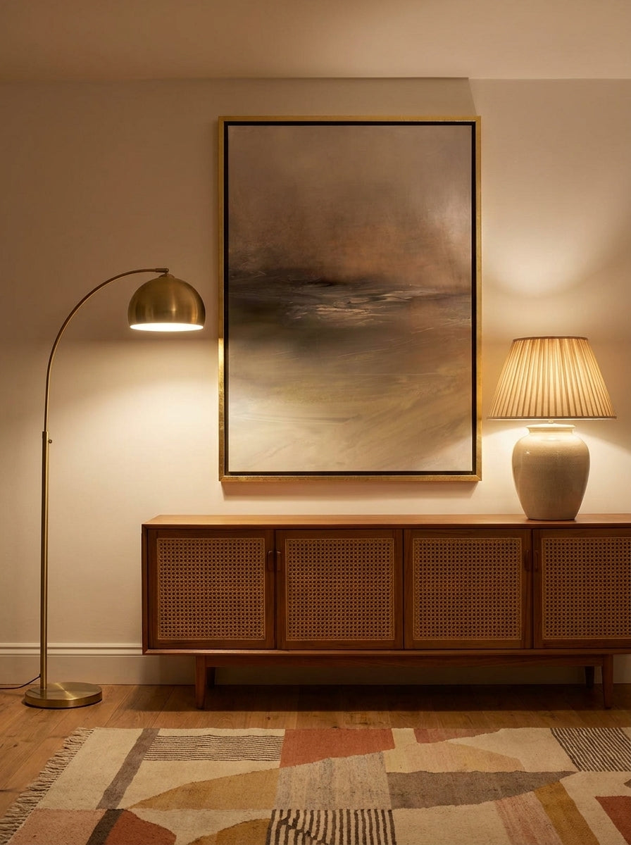 Canvas wall art with a gold leaf surround styled on the wall in a mid-century living room