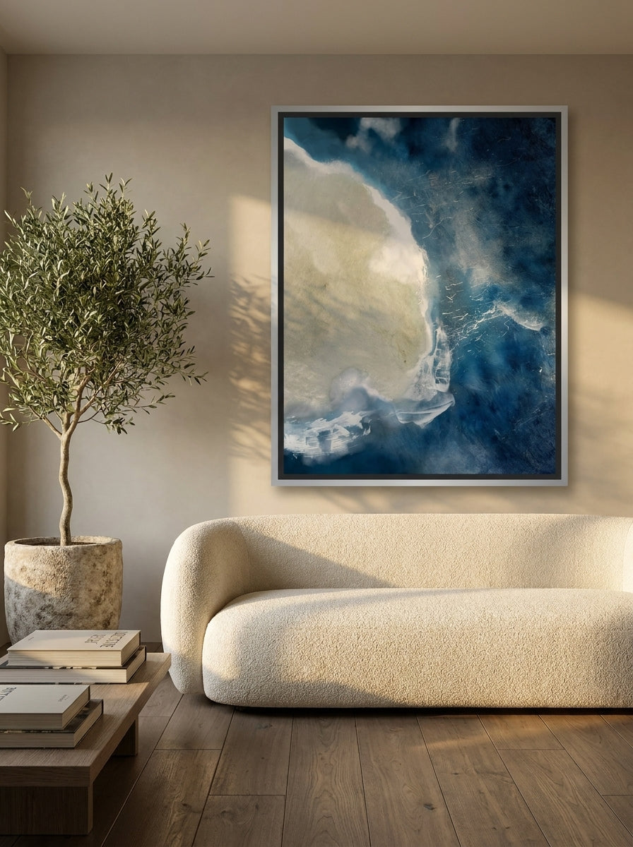 Oversized statement canvas wall art with a silver leaf surround styled on the wall in a luxe living room
