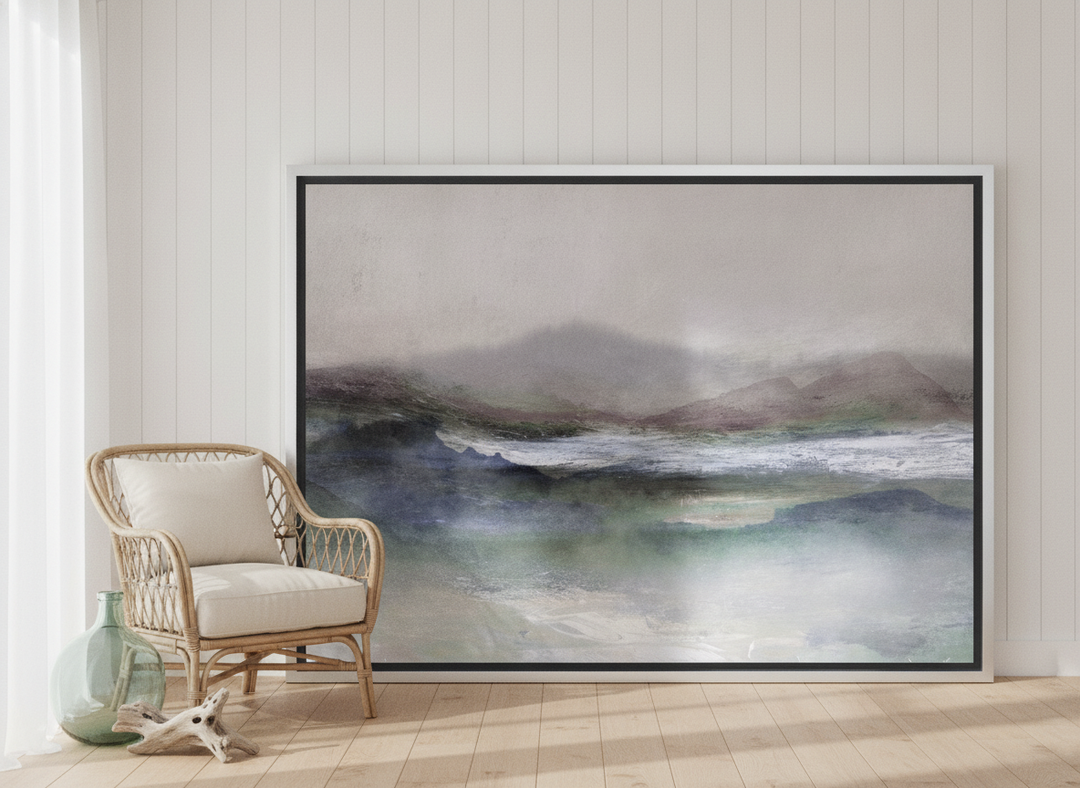 Oversized statement canvas wall art with a silver leaf surround leaning against the wall in a coastal living room