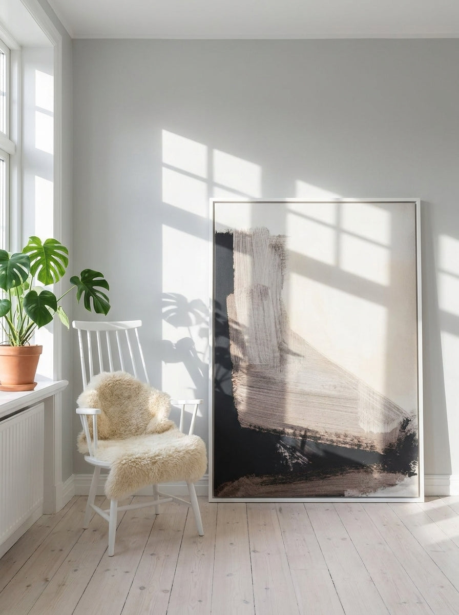 Canvas wall art with a white surround leaning against the wall in a bright Scandinavian home office