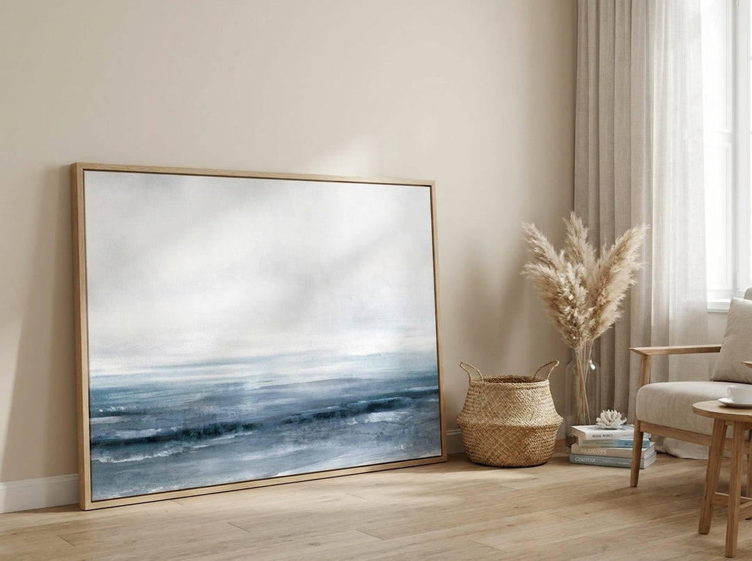 Oversized statement modern wall art print leaning against the wall in a coastal dining room