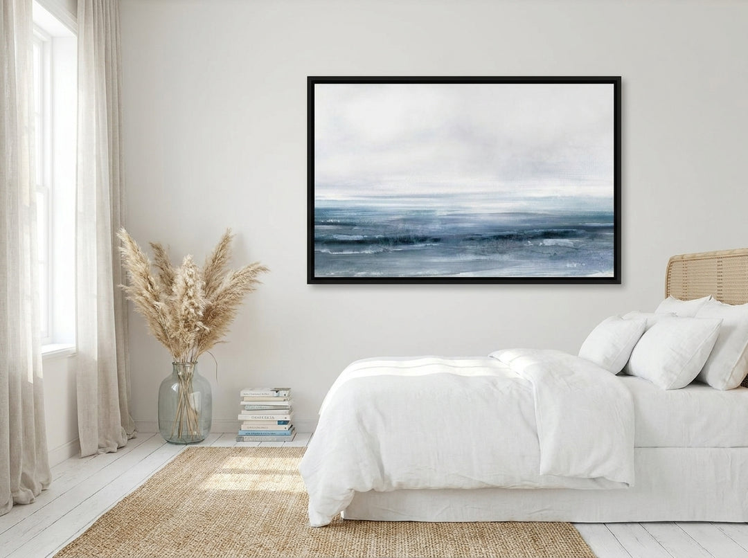 Oversized statement canvas wall art with a black surround styled on the wall in a coastal bedroom