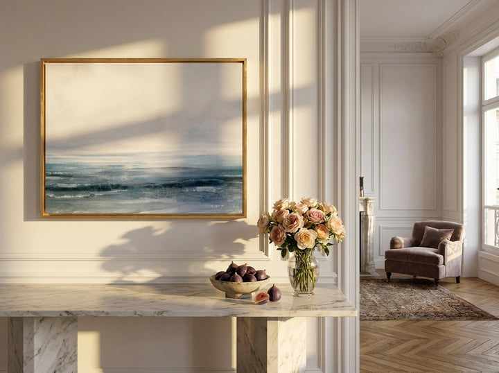 Oversized statement canvas wall art with a gold leaf surround styled on the wall in a Parisian living room