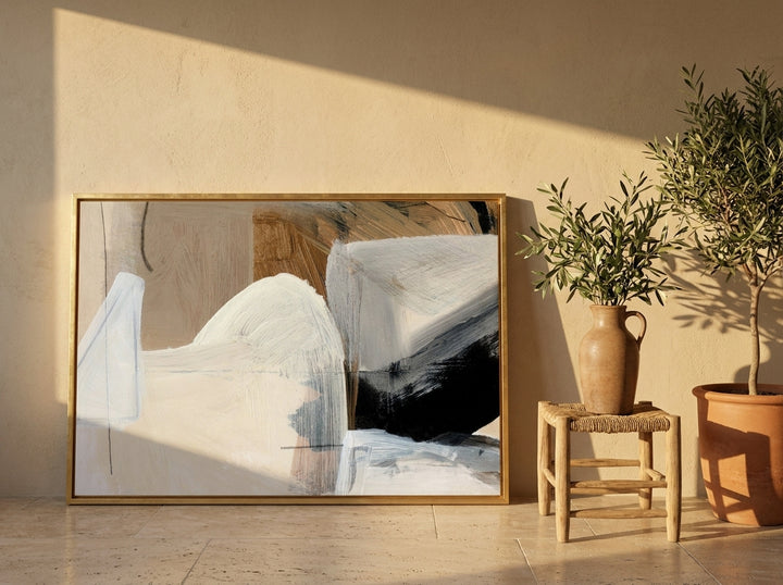 Canvas wall art with a gold leaf surround leaning against the wall in a Mediterranean home office