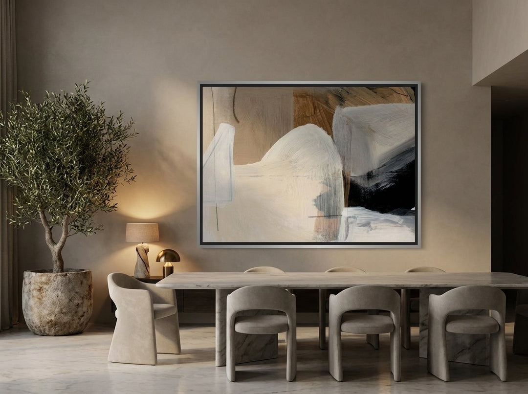 Oversized statement canvas wall art with a silver leaf surround styled on the wall in a luxe dining room