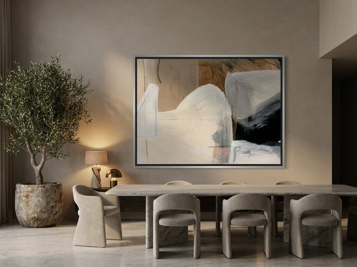 Oversized statement canvas wall art with a silver leaf surround styled on the wall in a luxe dining room