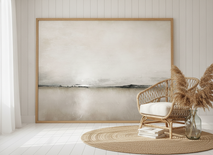 Oversized statement modern wall art print leaning against the wall in a coastal living room