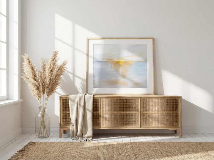 Modern wall art print standing on a sideboard in a coastal bedroom