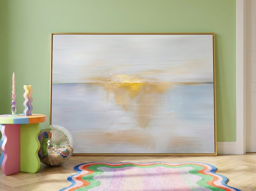 Oversized statement canvas wall art with a gold leaf surround leaning against the wall in a colourful eclectic living room