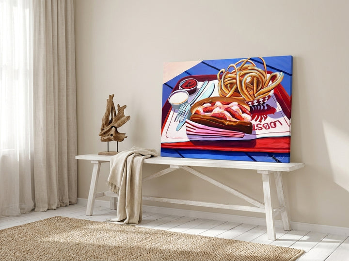Stretched canvas wall art standing on a console in a coastal dining room