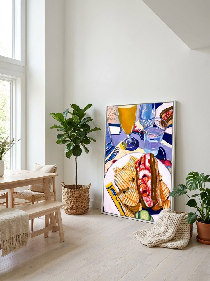 Oversized statement canvas wall art with a white surround leaning against the wall in a bright Scandinavian dining room