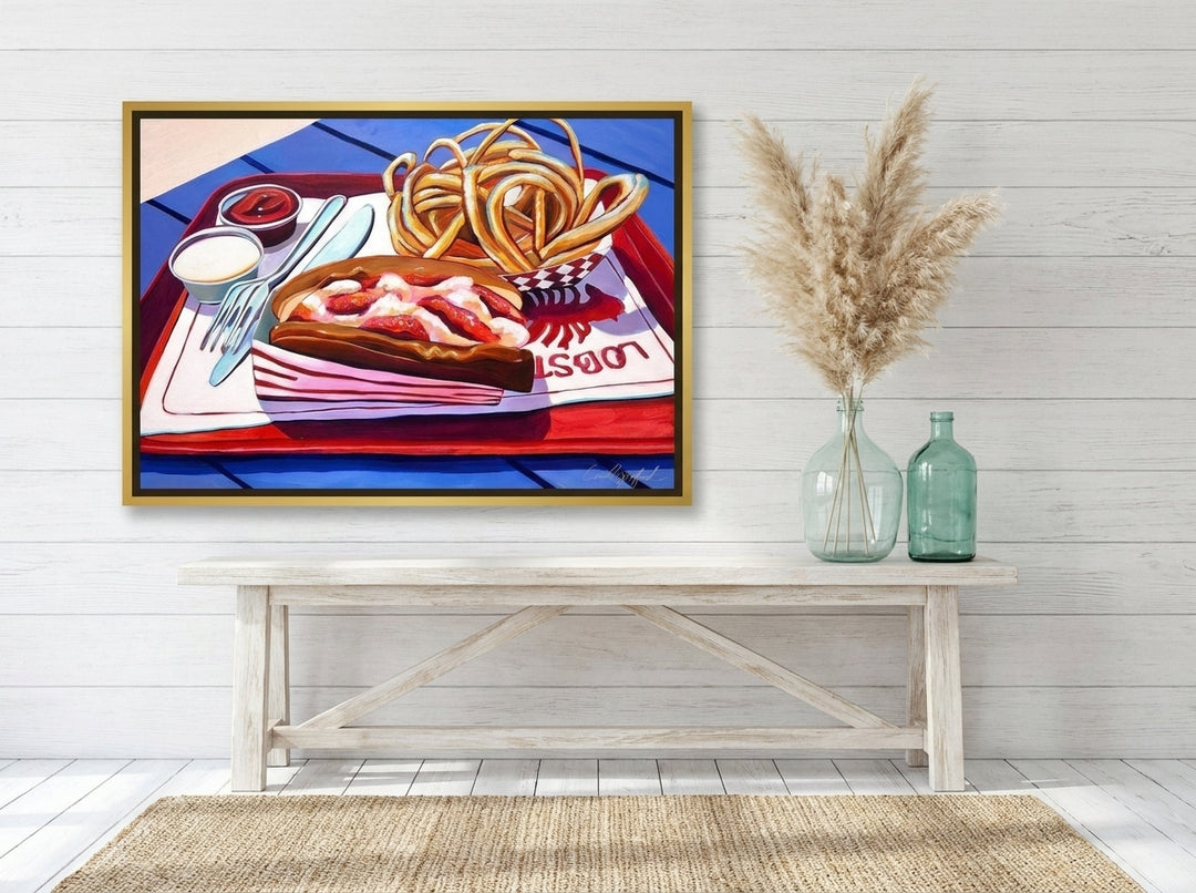 Canvas wall art with a gold leaf surround styled on the wall in a coastal living room