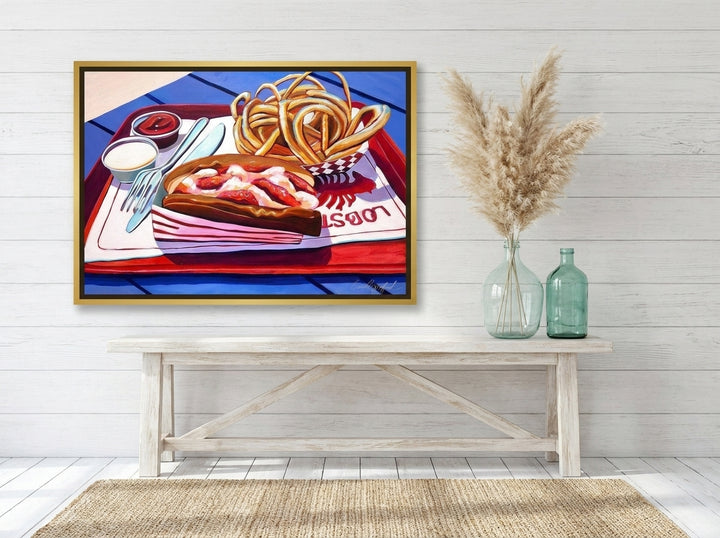 Canvas wall art with a gold leaf surround styled on the wall in a coastal living room