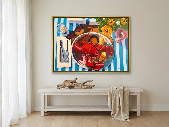 Oversized statement canvas wall art with a gold leaf surround styled on the wall in a coastal living room