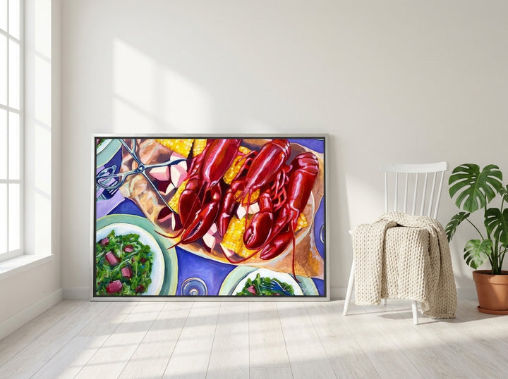 Canvas wall art with a silver leaf surround leaning against the wall in a bright Scandinavian living room